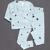 Light blue cotton pyjama set with black star print displayed on a gray background