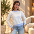 White pointelle sweater with thin blue stripes and blue ribbed trim, worn with light wash jeans