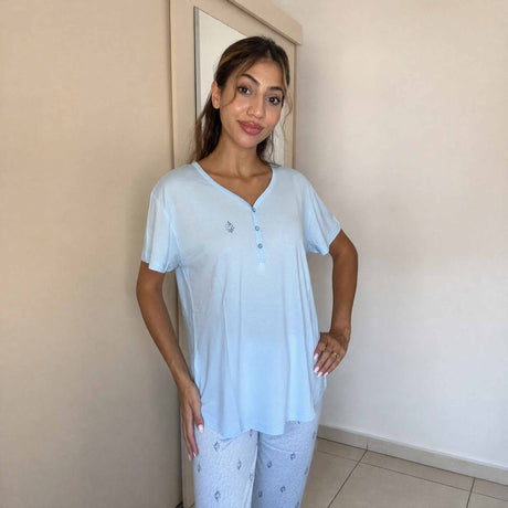 Button placket and embroidered chest motif on a pale blue pyjama top