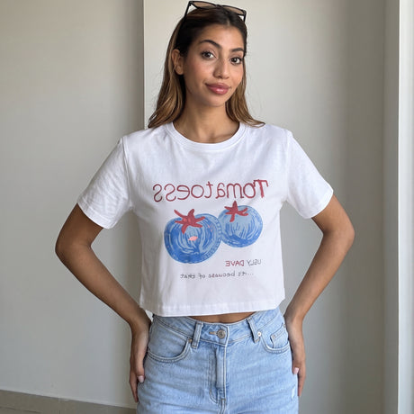 White cropped tee with a blue tomato graphic worn with light jeans