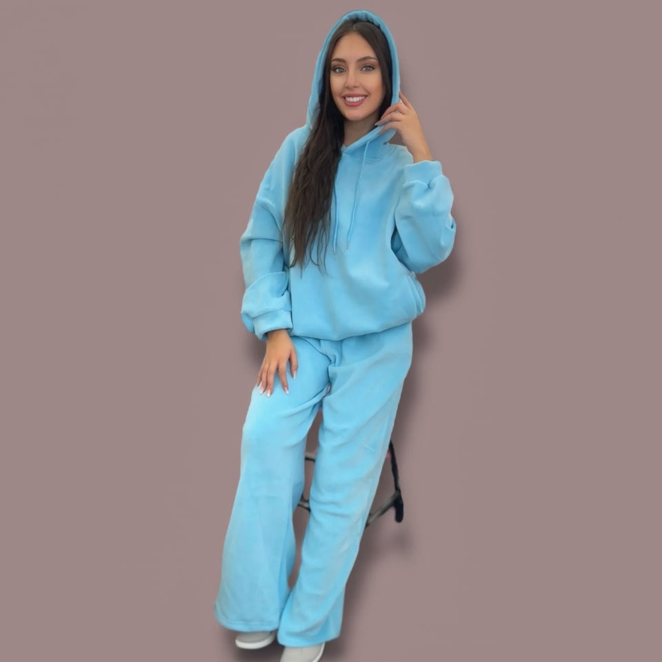 Woman wearing a blue jogging set against a brown background