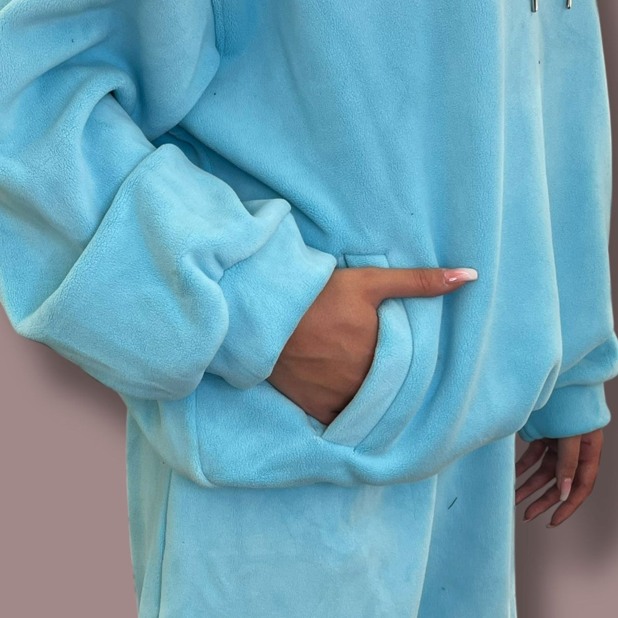 Close-up of a blue jogging set worn by a person with a neutral background