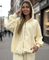 Woman wearing a yellow hoodie and sweatpants on a street