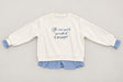 Cream crew neck sweatshirt laid flat with blue embroidered script and gingham trim