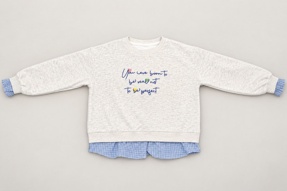 Grey marl crew neck laid out flat, navy script across the chest and blue frills at each wrist