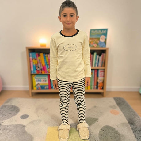 Boys cream long sleeve top with black neck trim and striped pyjama leggings