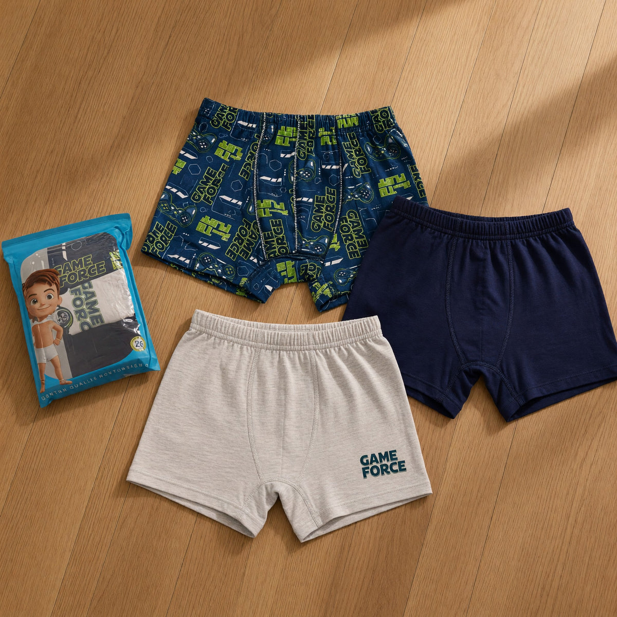 Three boys boxers in a navy game controller print, plain navy and grey with lettering beside the pack