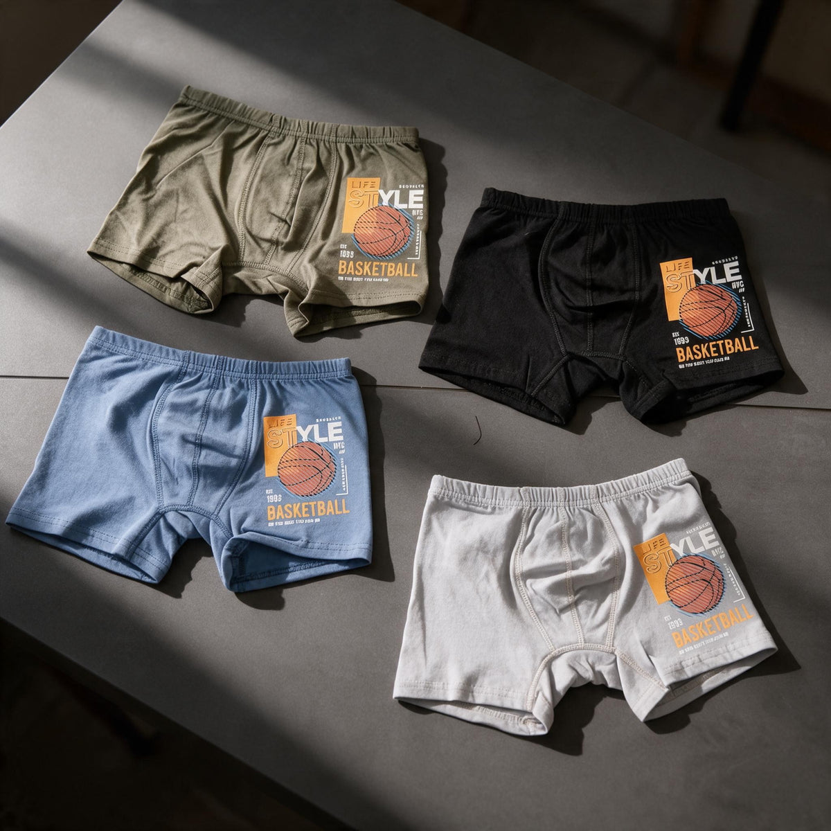 Four boys boxers in olive, black, blue and grey with an orange basketball print