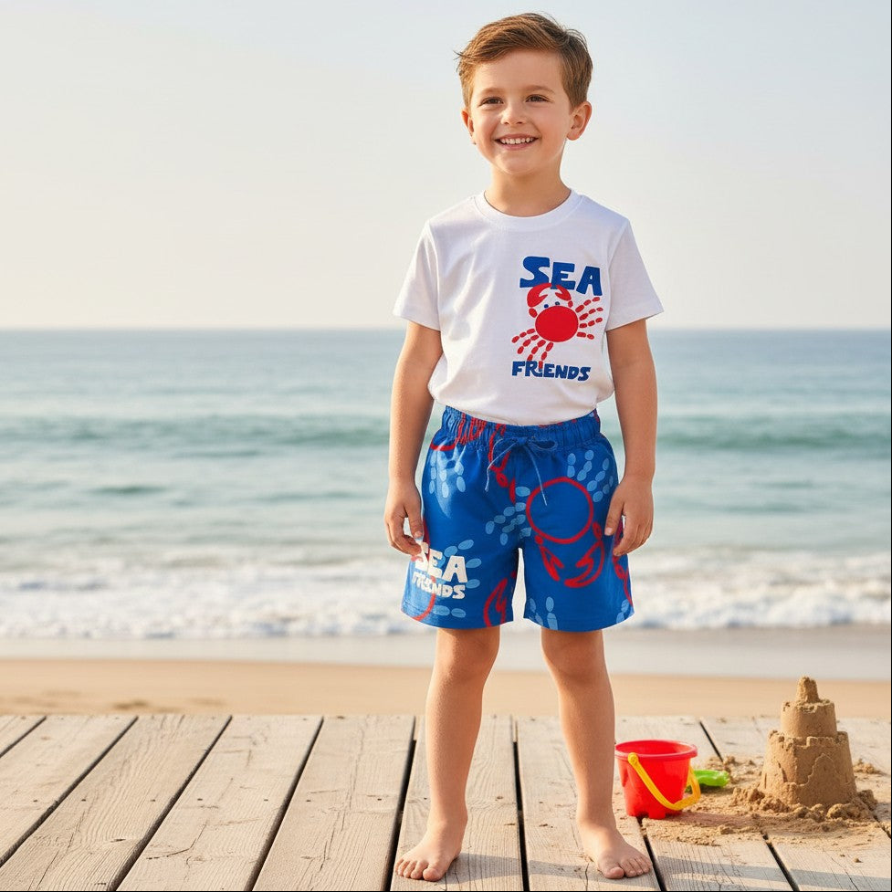 Child wearing a 'Sea Friends' t-shirt and blue shorts on a beach