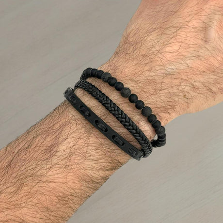 All black lava bead, braided and studded leather bracelet stack on a wrist