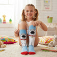 Kids light blue knee high socks with a white cartoon dog print and bright red toes, worn seated
