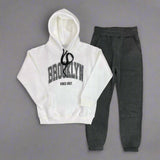 White hoodie with Brooklyn Vibes Only print laid out with charcoal joggers