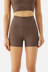 Brown athletic top and shorts worn by a person on a white background