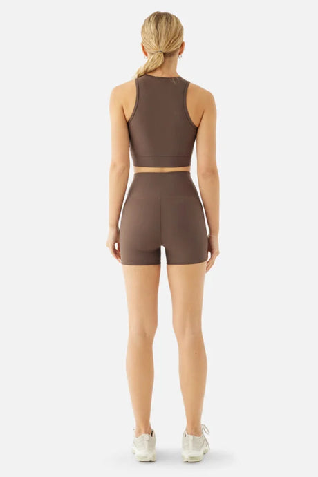 Person wearing a brown athletic outfit on a white background