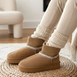 Brown winter boots with white trim worn indoors on a woven mat.
