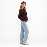 Side view of a brown brushed knit sweater with straight leg jeans, full length