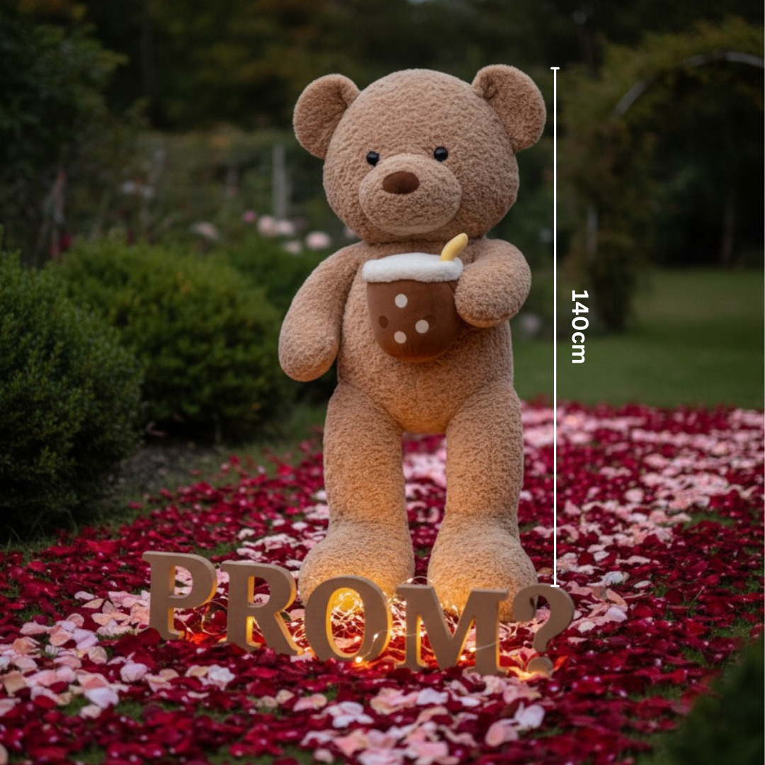 Caramel curly teddy bear holding a boba cup plush beside glowing letters