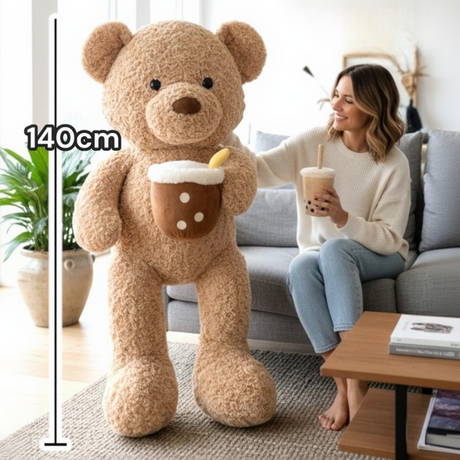 Caramel brown teddy bear beside a seated woman, with a 140cm measuring line
