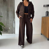 Full length view of the brown zip hoodie set with wide leg trousers and trainers