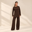 Chocolate brown knit sweater and wide leg trousers set, standing in a bright room