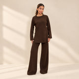 Chocolate brown knit sweater and wide leg trousers set, standing in a bright room