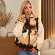 Woman in a sherpa zip jacket with white deer and pine trees on a sand and rust front with cream sleeves