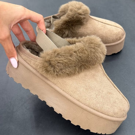 Hand lifting a camel platform slipper with a thick fur collar