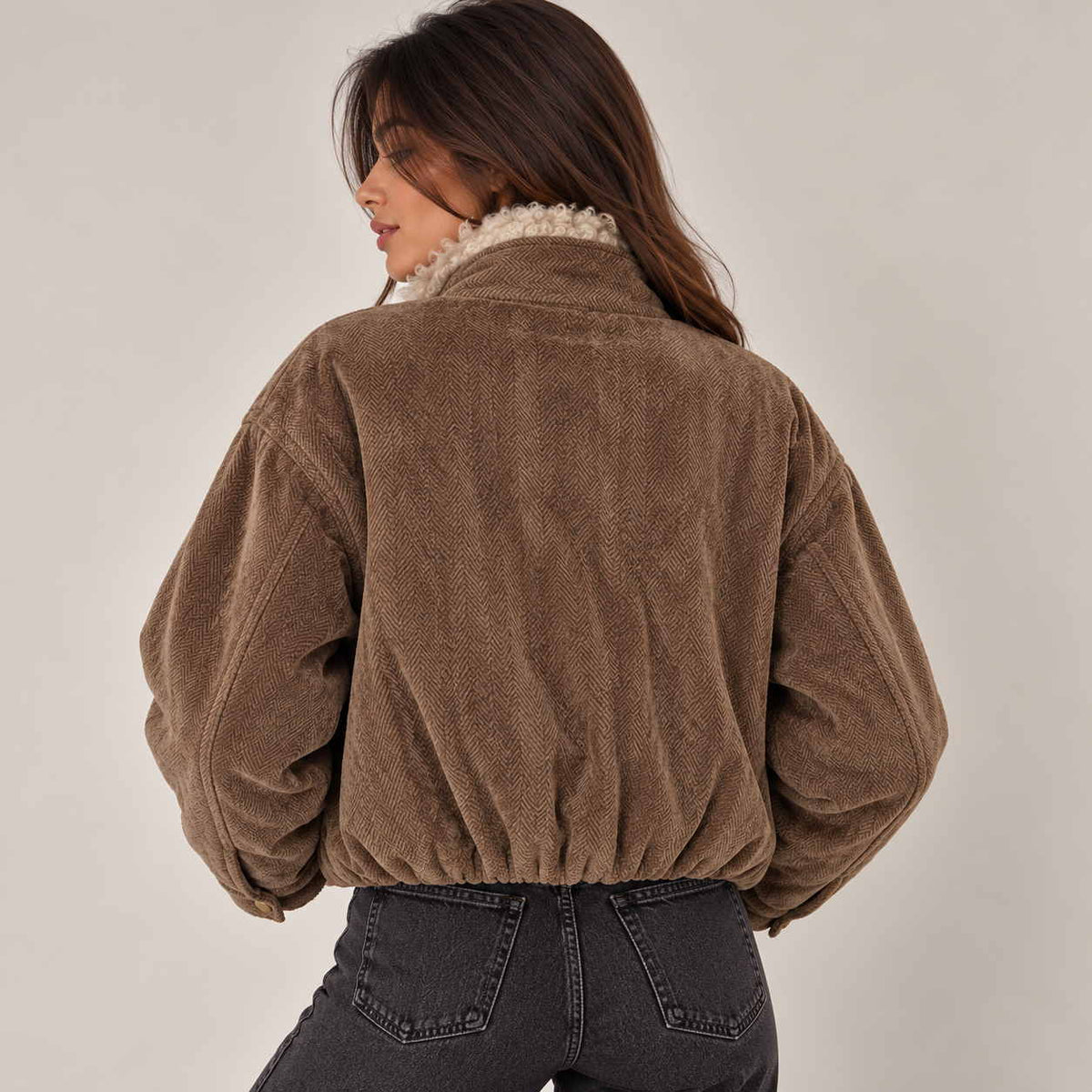 Back view of a brown herringbone jacket with an elasticated hem