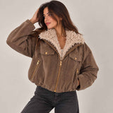 Brown herringbone bomber jacket with cream sherpa collar worn open over a white top
