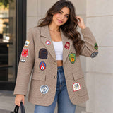 Woman in a brown houndstooth blazer covered in colourful embroidered patches with jeans