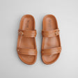 Pair of brown sandals with 'Nice' branding on a light gray background