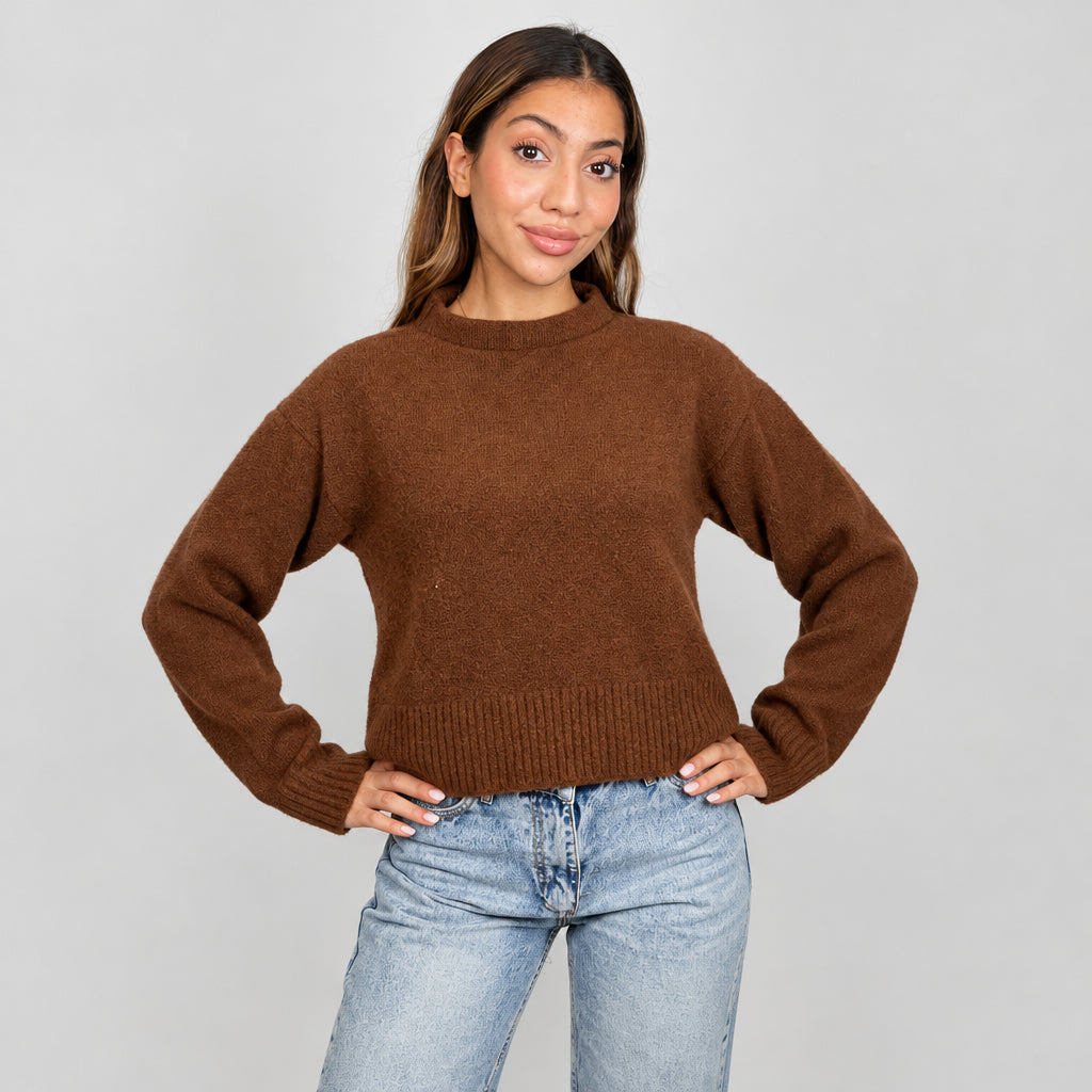 Rust brown cropped mock neck sweater with a ribbed hem, hands on hips with light jeans