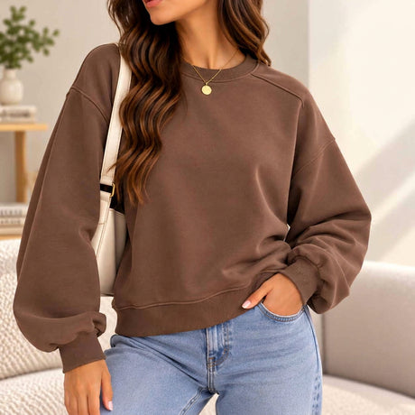 Woman in a mocha brown oversized crew neck sweatshirt with dropped shoulders and jeans