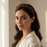 Brown padded headband worn with long dark waves and a white shirt