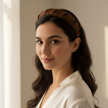 Brown padded headband worn with long dark waves and a white shirt
