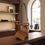 Brown handbag on a wooden surface with a blurred indoor background