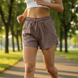 Person wearing active shorts running on a path in a park with trees and grass in the background
