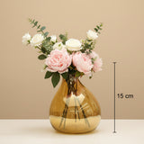 The smaller amber bubble vase marked 15 cm, holding peonies and white roses