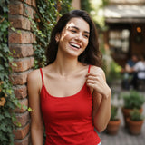 Red cami top with adjustable spaghetti straps worn against a brick wall