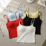 Five strappy cami tops in light blue, yellow, red, black and white laid flat