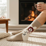 Person wearing cozy socks with cartoon bunny designs in front of a fireplace.