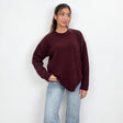 Burgundy chunky wool knit sweater with a crew neck, hand in pocket with light wash jeans