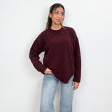 Burgundy chunky wool knit sweater with a crew neck, hand in pocket with light wash jeans