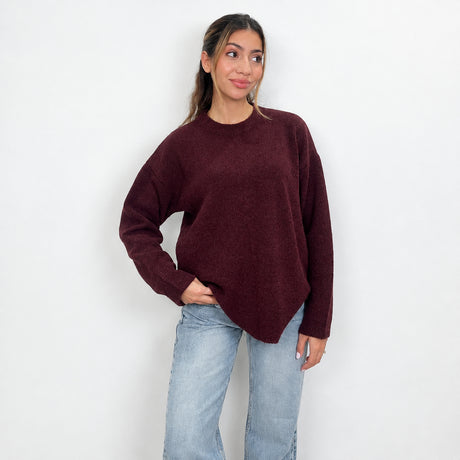 Burgundy chunky wool knit sweater with a crew neck, hand in pocket with light wash jeans