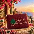 Handmade burgundy pouch with gold Arabic I love you Lebanon embroidery and a green cedar on a Lebanese terrace