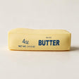 Pastel yellow butter stick squishy printed with Salted Butter in blue on a white background
