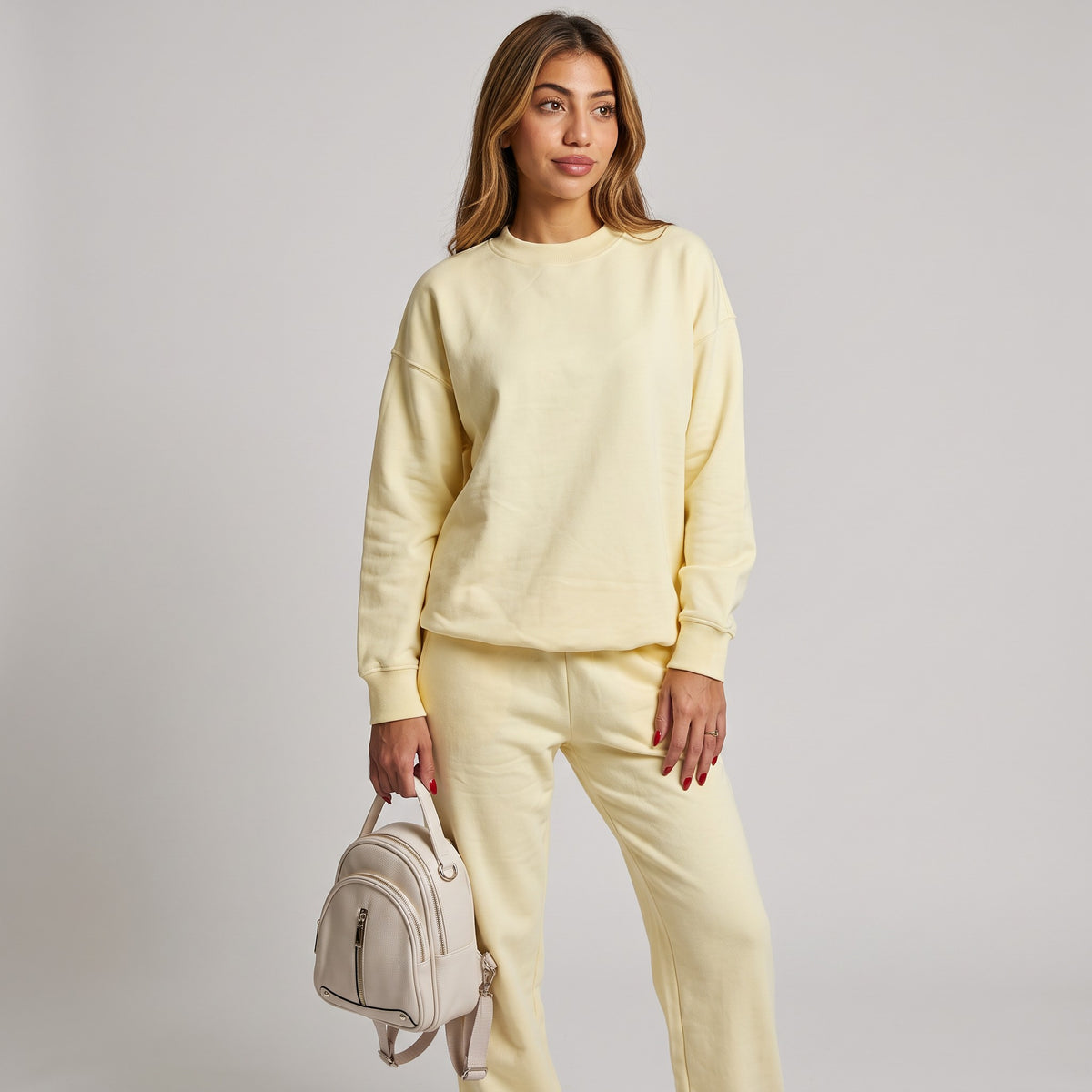 Three quarter angle of the pale yellow crew neck sweatshirt with ribbed cuffs and hem