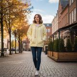 Butter yellow zip hoodie with a lined hood worn open on a tree lined street
