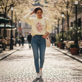 Butter yellow tulip print sweatshirt worn walking a cobbled street with a tote