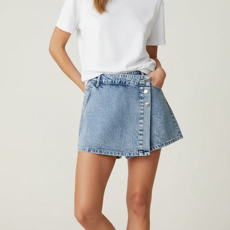 Woman wearing a white tshirt and button denim skirt on a plain background